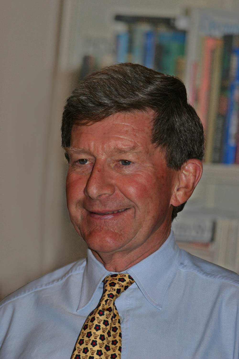 James Eric Ormsby smiling and wearing a shirt and tie.